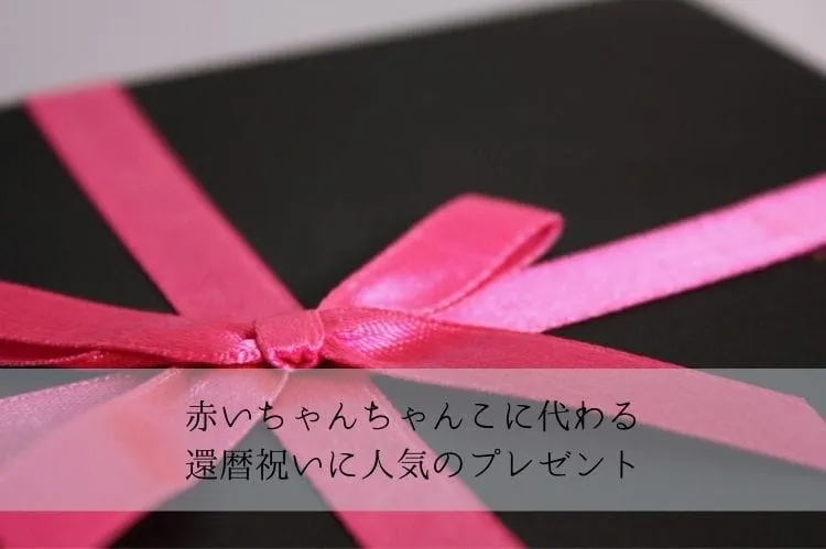 黒の包みにピンクのリボンがついたプレゼントボックス