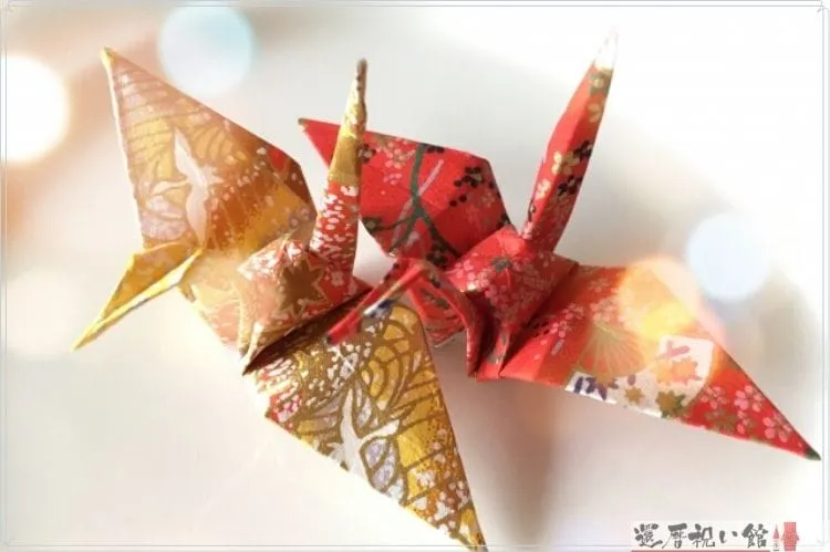 和柄の折り紙で折られた赤と黄色の折り鶴