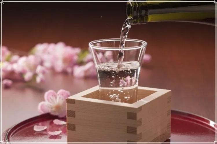 枡に入ったグラスに日本酒が注がれている
