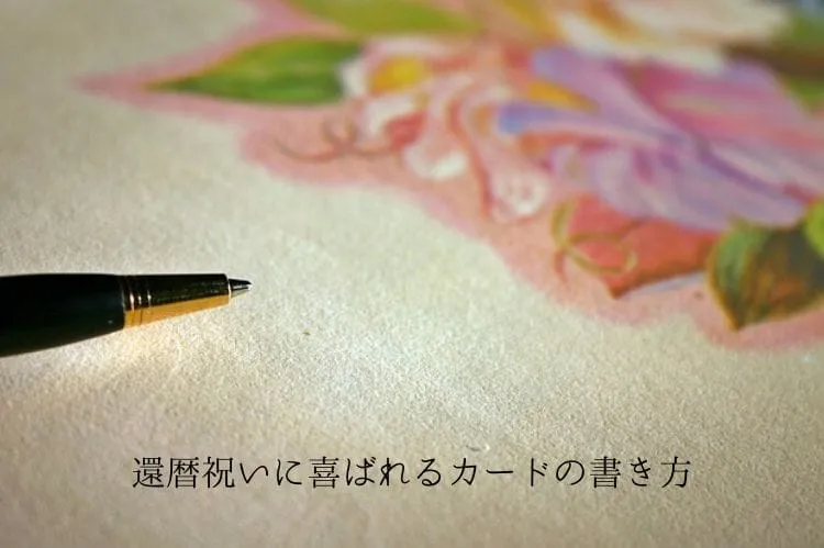 白く粗い紙にペンが置かれ、その奥に紫やピンクの花が描かれている